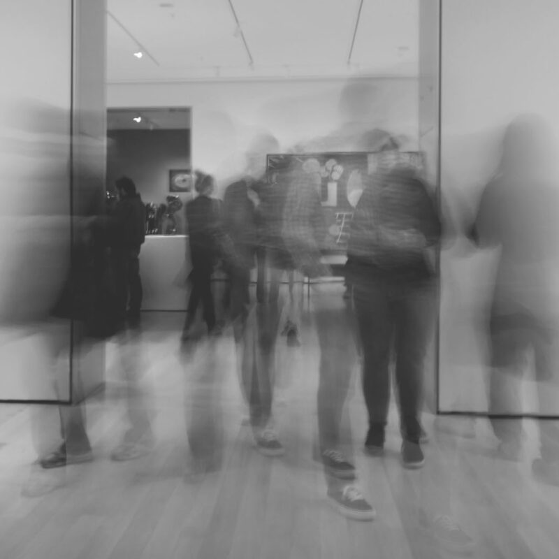 Visitors moving through a gallery exhibition. Studio Willis.