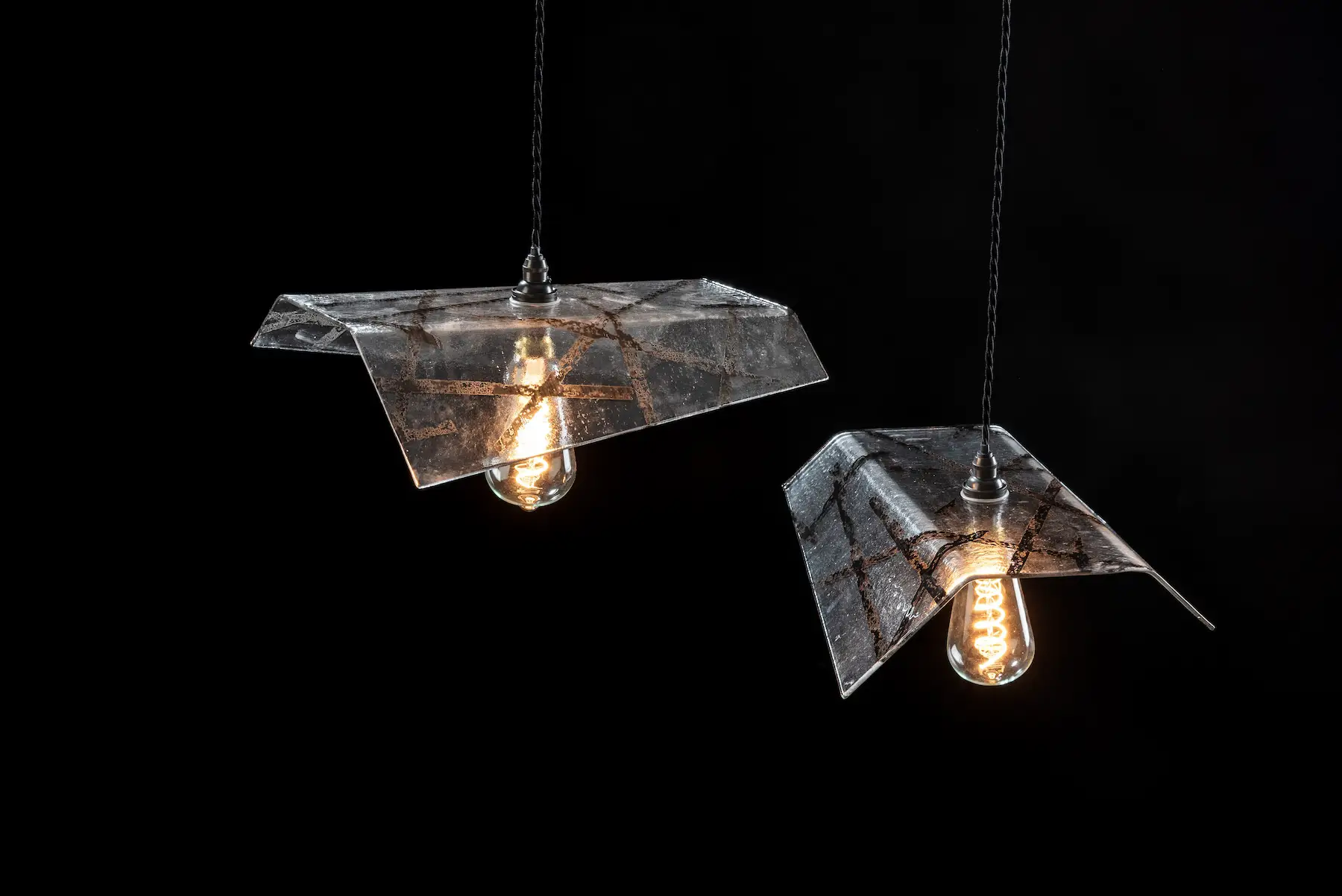 Staggered Pair — Fritz Fryer Lighting, staggered pair of folded screen printed glass pendants with filament bulbs. Studio Willis.